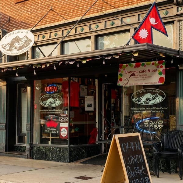 Everest Cafe & Bar storefront with an awning, Nepalese flag, and an "Open Lunch Buffet" sign.